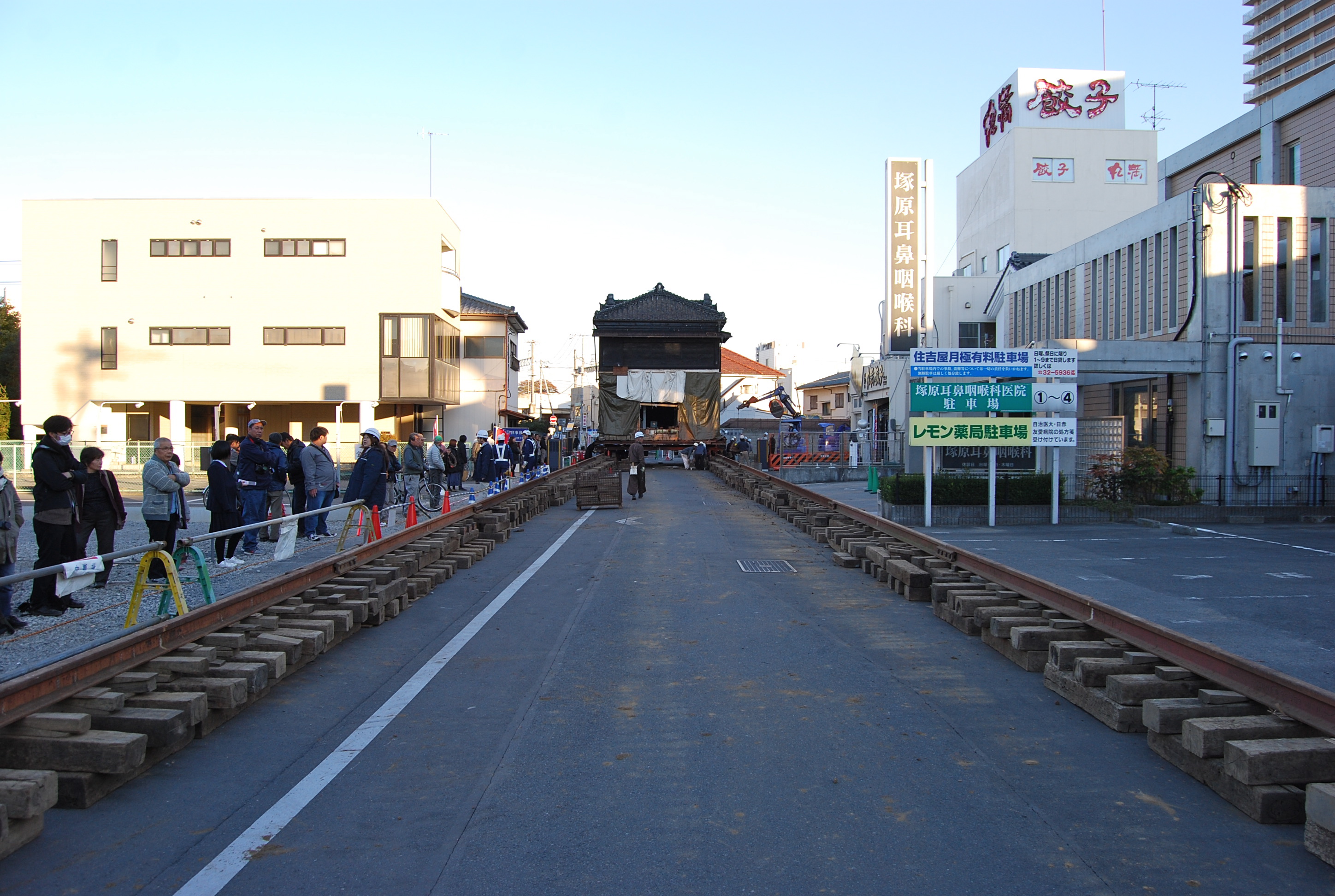 曳家の様子　道路上にレールを敷設し、 車輪の付いた器具を建物の底面に取り付けて曳く