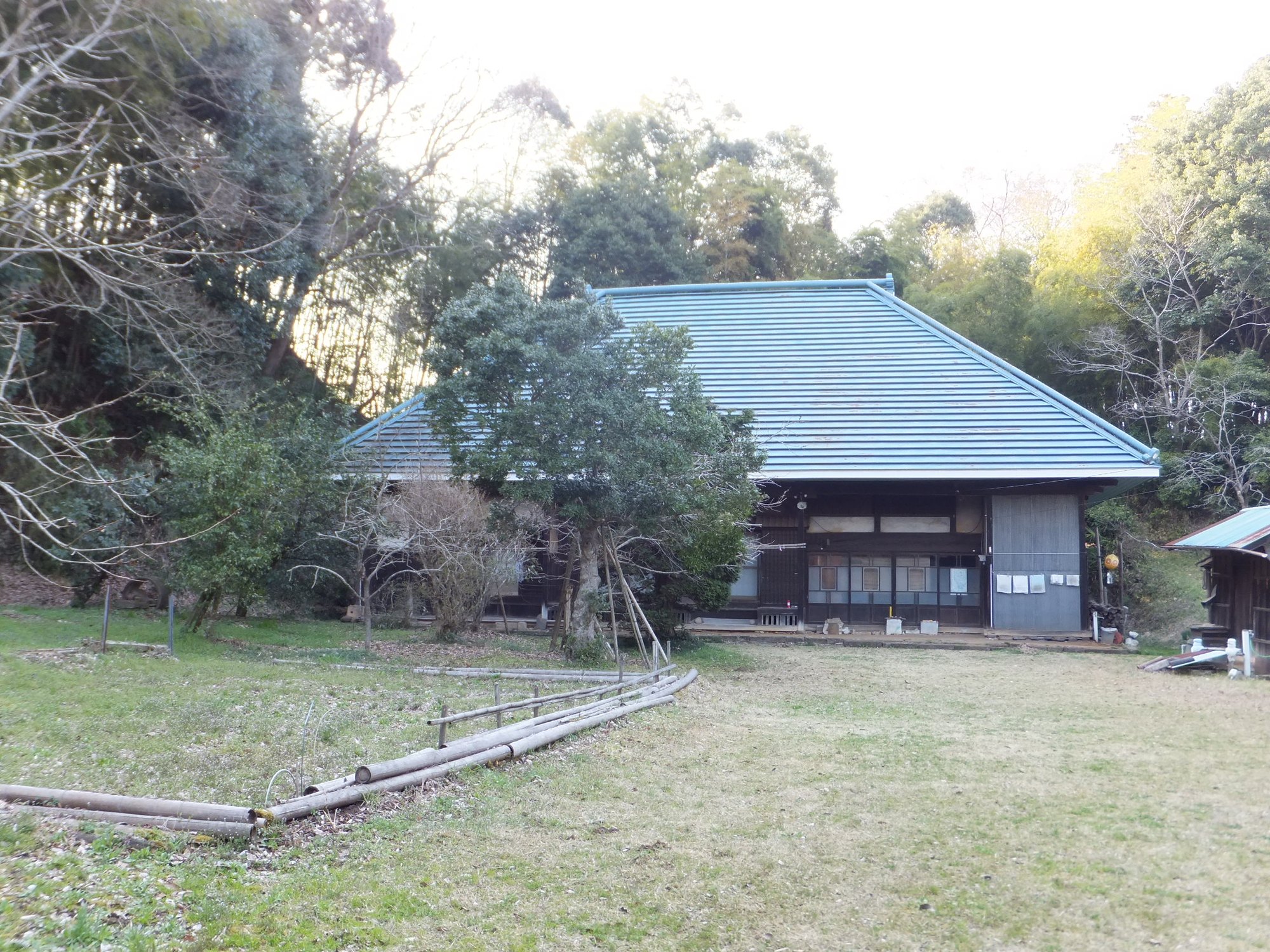 屋敷林を背にして建つ農家の住まい